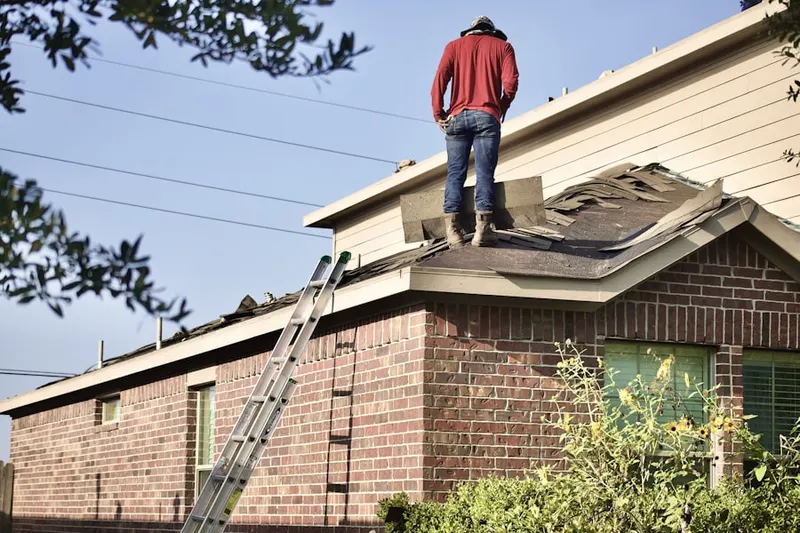 Professional roofer working on a residential roof in Paxson